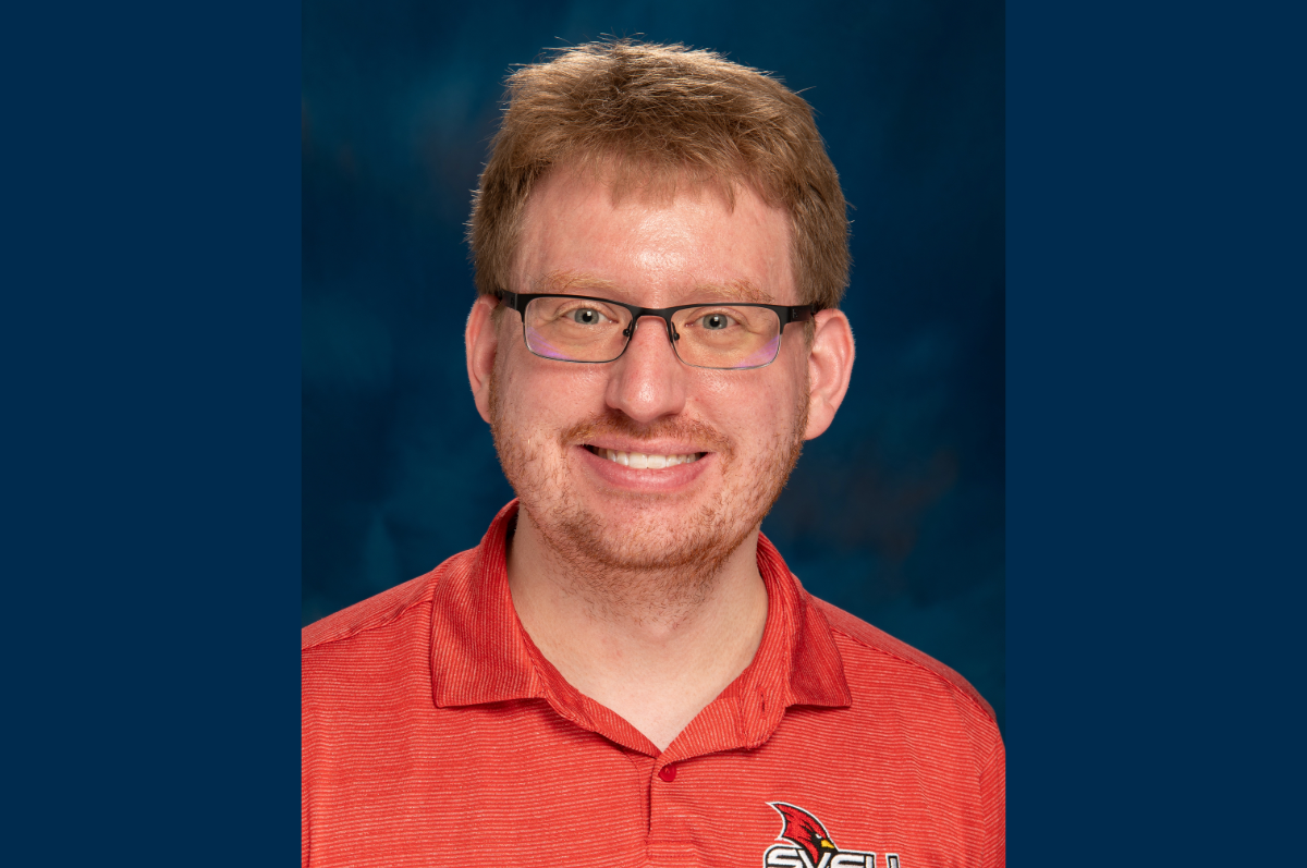 Man in red shirt looks at camera